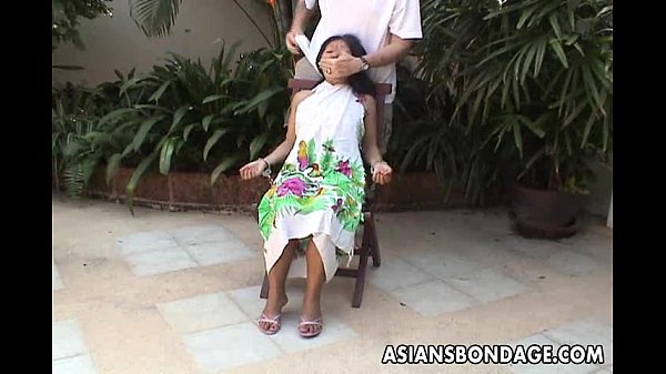 Teen asiatica legata e mano ammanettata su una sedia