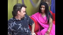 La giovane donna indiana dà a un uomo più anziano un pompino su un divano rosso