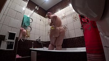 Detrás de escena, una cámara oculta espiando a una modelo porno gorda con un gran culo en el baño.