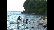 湖の岸で叩いている熱い裸の入浴者