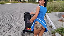 Charmante mère en robe bleue sans culotte lors d'une promenade dans la rue.