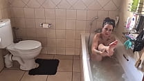 Fully tattooed young MILF with small boobs bathing herself in the bathtub