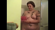 Tattooed fat chick strips to wash her tits and cunt in the shower