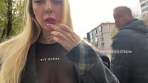 Una niña muestra sus senos mientras camina en público en la ciudad
