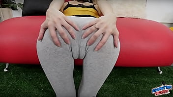 Chica flaca tiene un enorme hueco entre los muslos y un culo redondo en pantalones de yoga ajustados