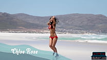 La pequeña modelo asiática Chloe Rose hace un striptease en bikini en la playa