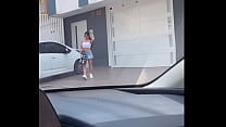 young cowgirl receiving crowbar in a driver's car in a public area